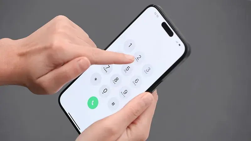 Main d'une personne composant un numéro de téléphone sur un smartphone