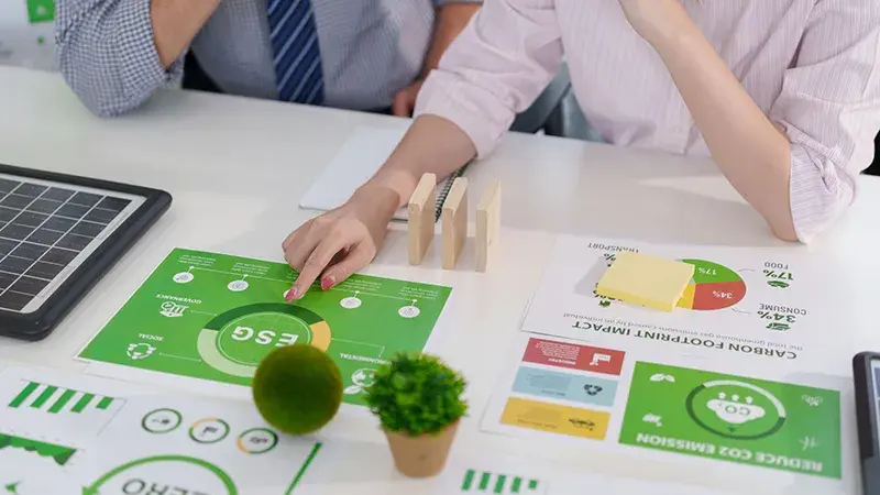 Un homme et une femme au bureau étudient des documents relatifs à l'environnement